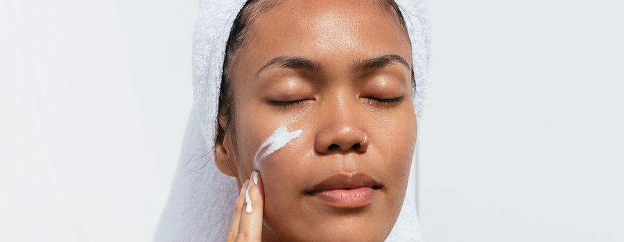 Woman applying moisturiser to her cheek