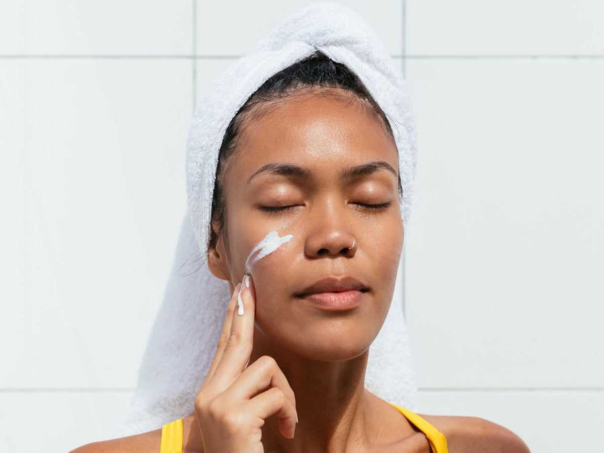 Woman applying moisturiser to her cheek